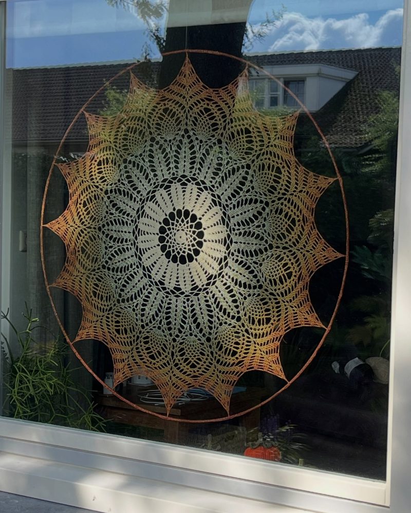 Grote gehaakte mandala van 90 centimeter voor het raam